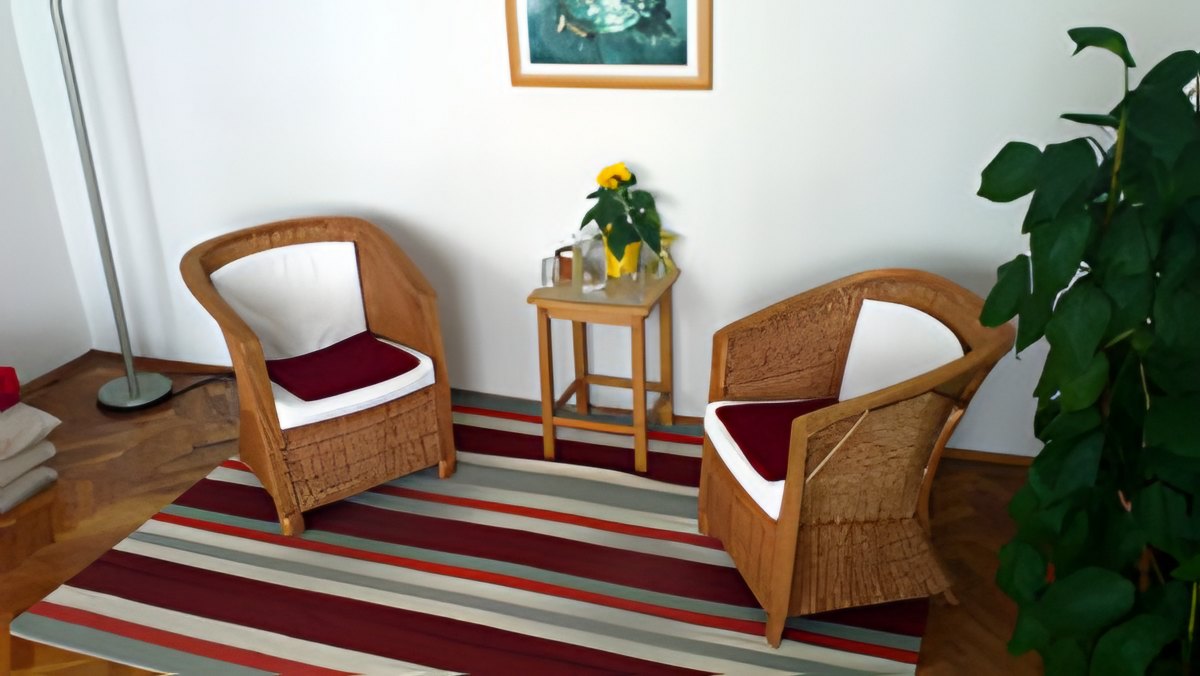 Therapieraum mit zwei Korbsesseln, Blumen und Pflanzen